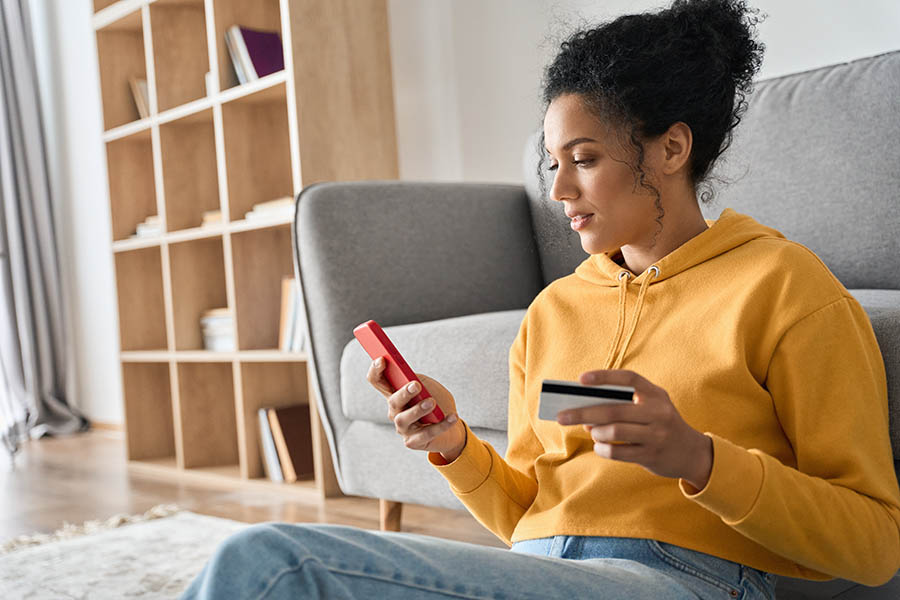 Girl sitting indoors doing mobile payment online.